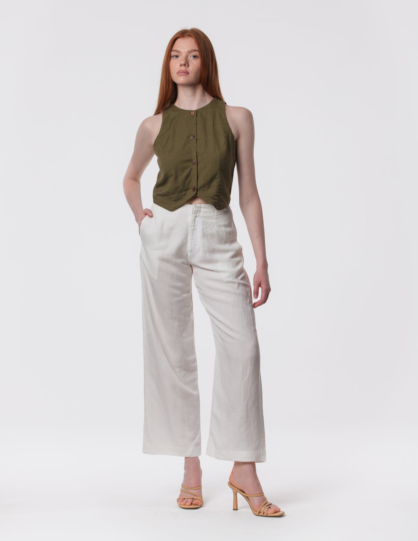 Model wearing high-waisted wide-leg linen pants in white with a relaxed fit and tailored waist by Artemizelle