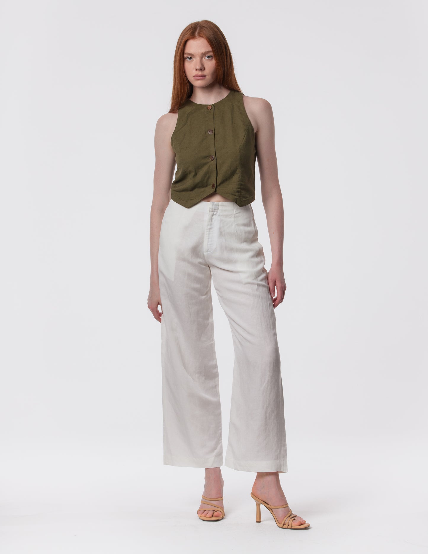 Model wearing high-waisted wide-leg linen pants in white with a relaxed fit and tailored waist by Artemizelle