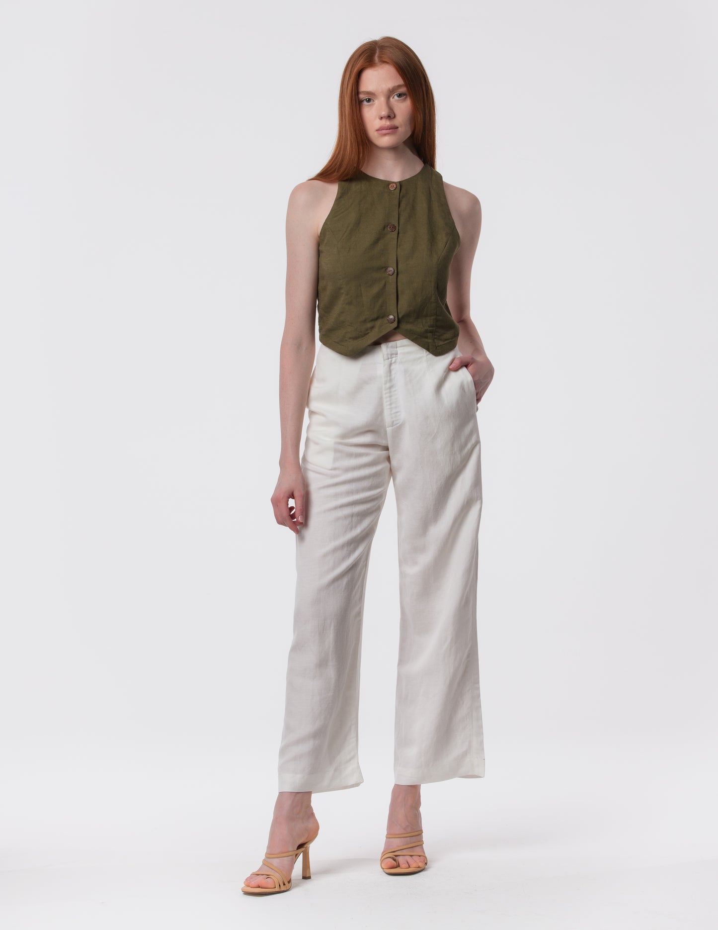 Model wearing high-waisted wide-leg linen pants in white with a relaxed fit and tailored waist by Artemizelle
