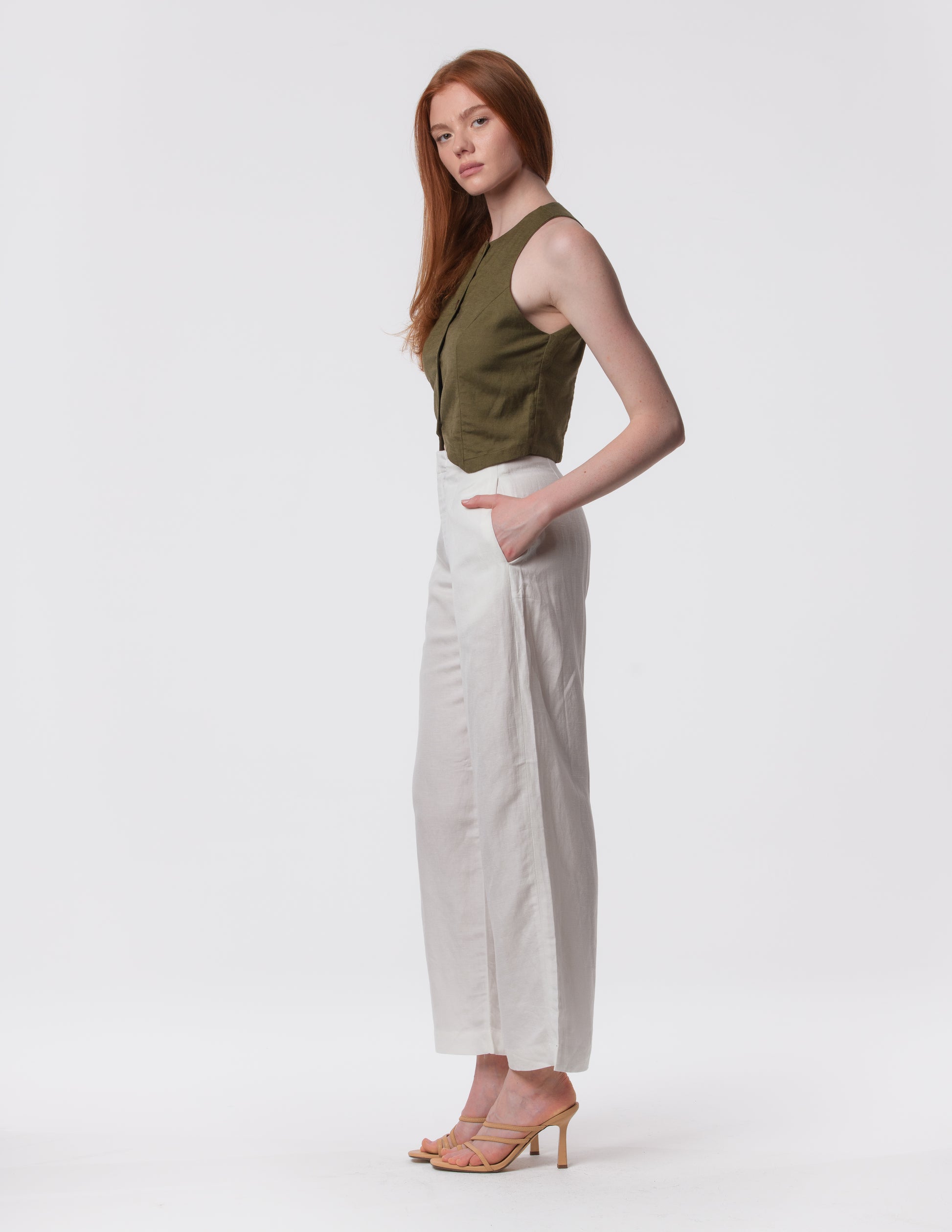 Model wearing high-waisted wide-leg linen pants in white with a relaxed fit and tailored waist by Artemizelle