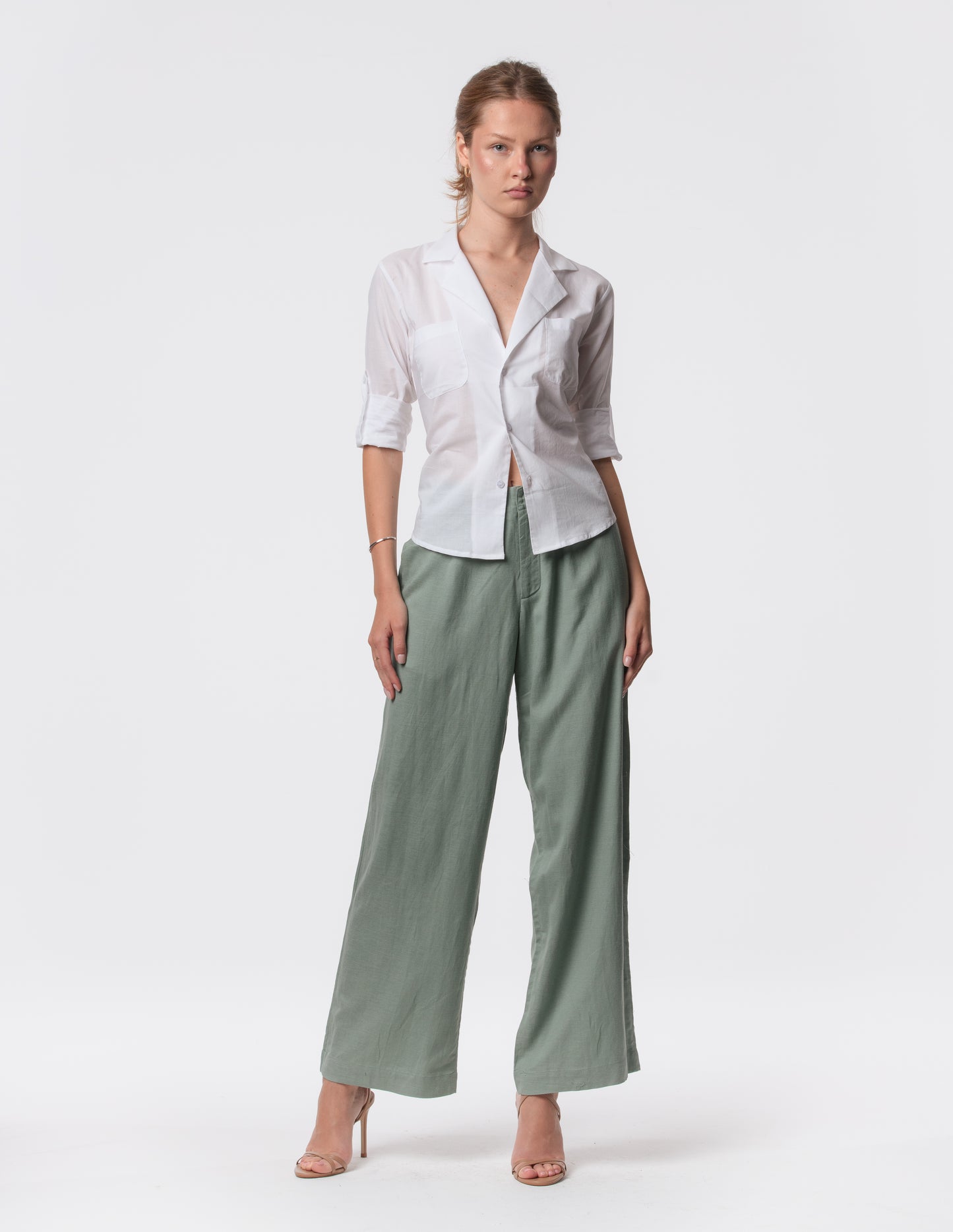 Model wearing high-waisted wide-leg linen pants in white with a relaxed fit and tailored waist by Artemizelle