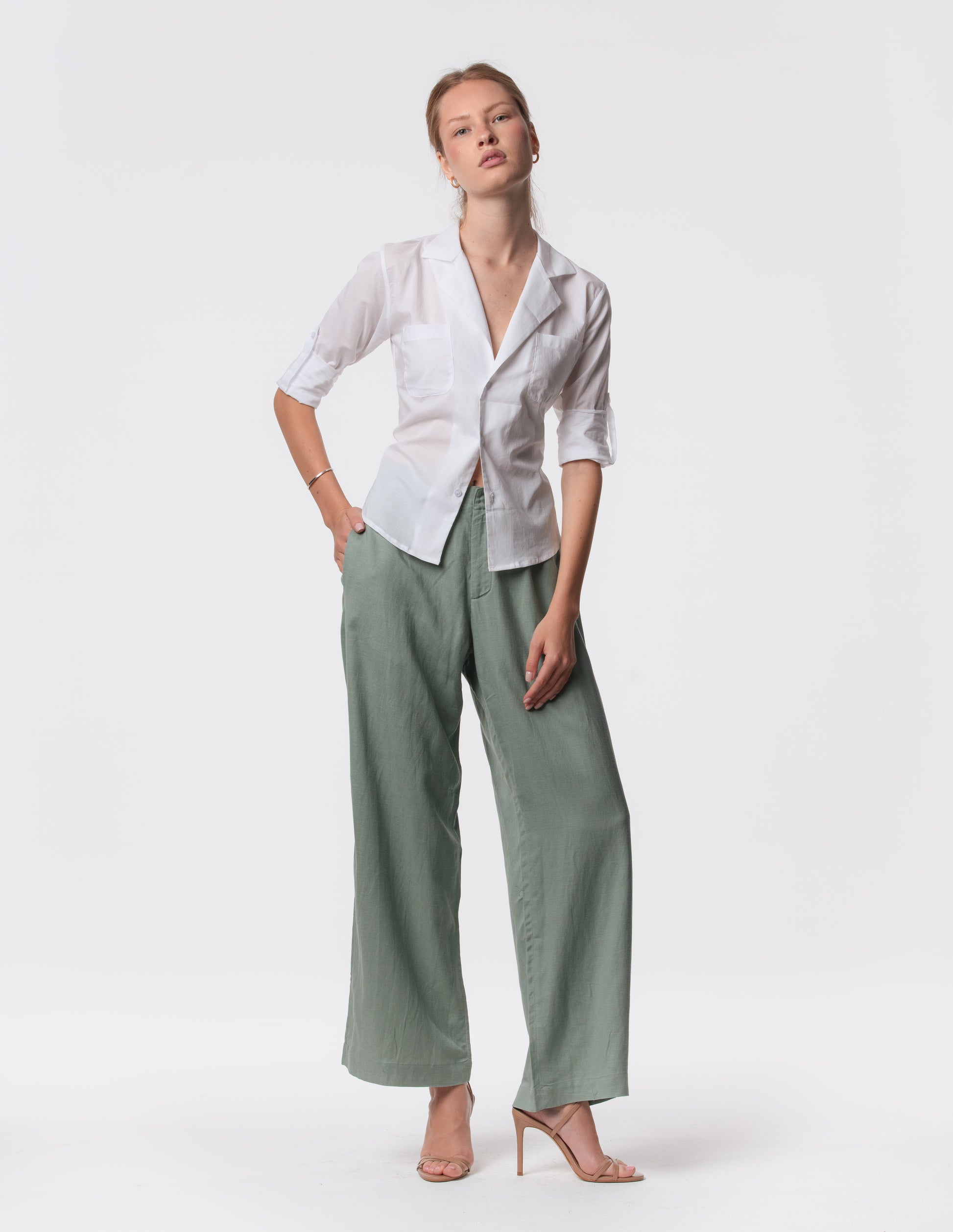 Model wearing high-waisted wide-leg linen pants in Green with a relaxed fit and tailored waist by Artemizelle