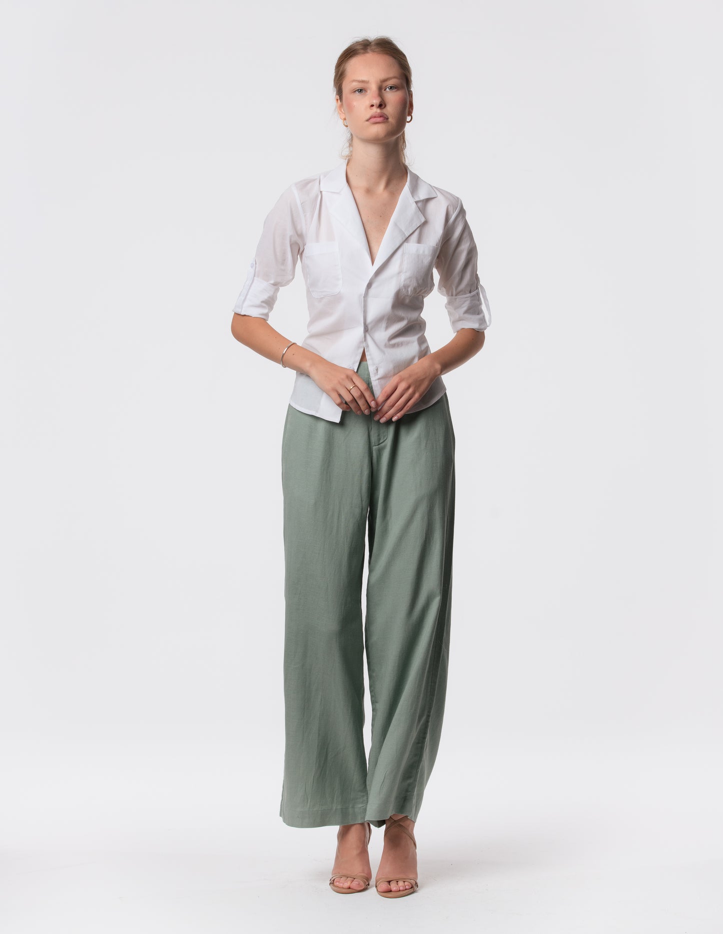 Model wearing high-waisted wide-leg linen pants in Green with a relaxed fit and tailored waist by Artemizelle